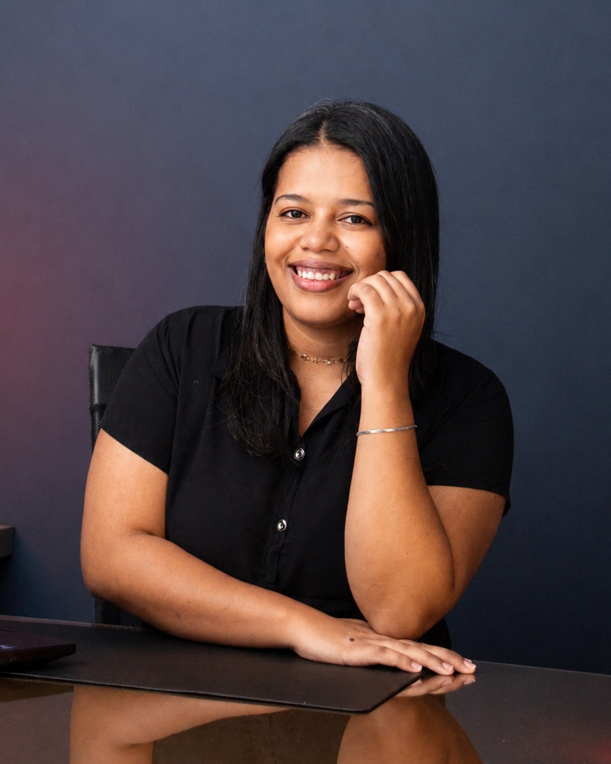 Taís Marina, arquiteta e urbanista, sorrindo em sua mesa de trabalho